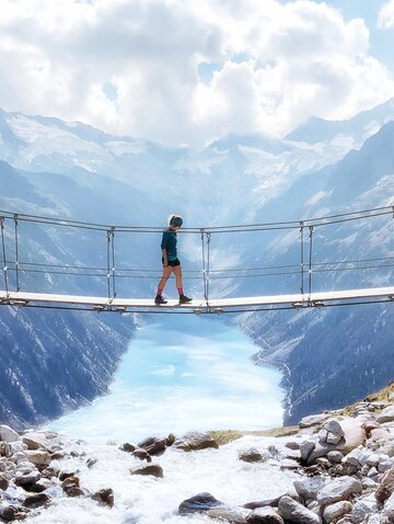 Frau überquert Hängebrücke bei der Olperer Hütte