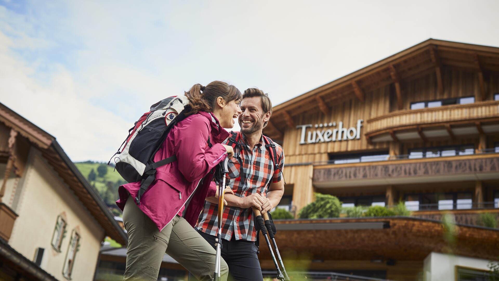 Wanderndes Paar vor dem Hotel Tuxerhof im Sommer