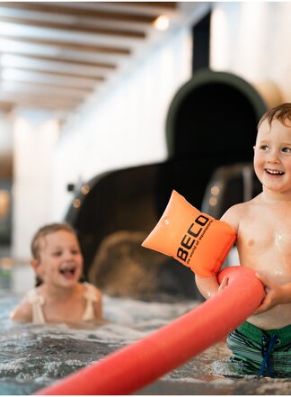 Kind spielt fröhlich im familienfreundlichen Indoor-Wellnessbereich des Tuxerhofs