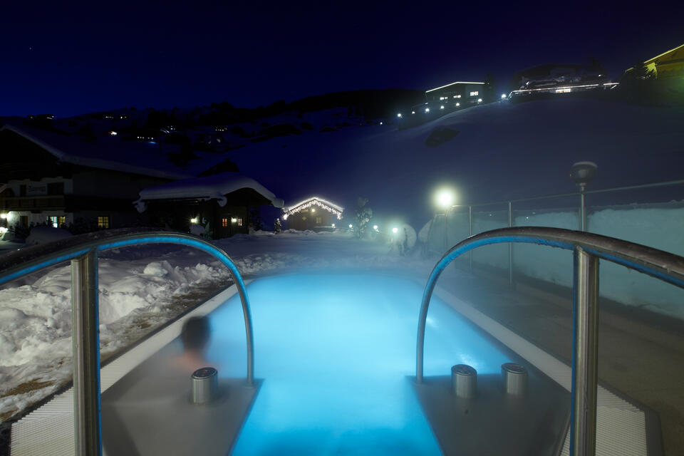 outdoor Pool bei Nacht im Wellnessurlaub Zillertal