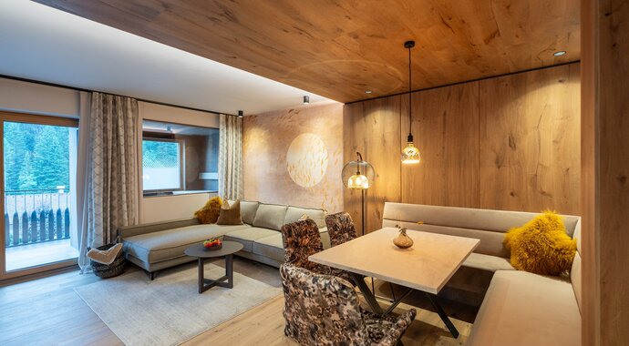 Living room with sofa, table, chairs and wood paneling